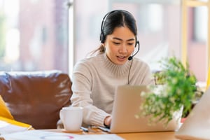 Woman on computer using headset