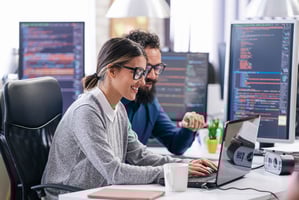 persons in an office working on laptop with Microsoft Teams Phone
