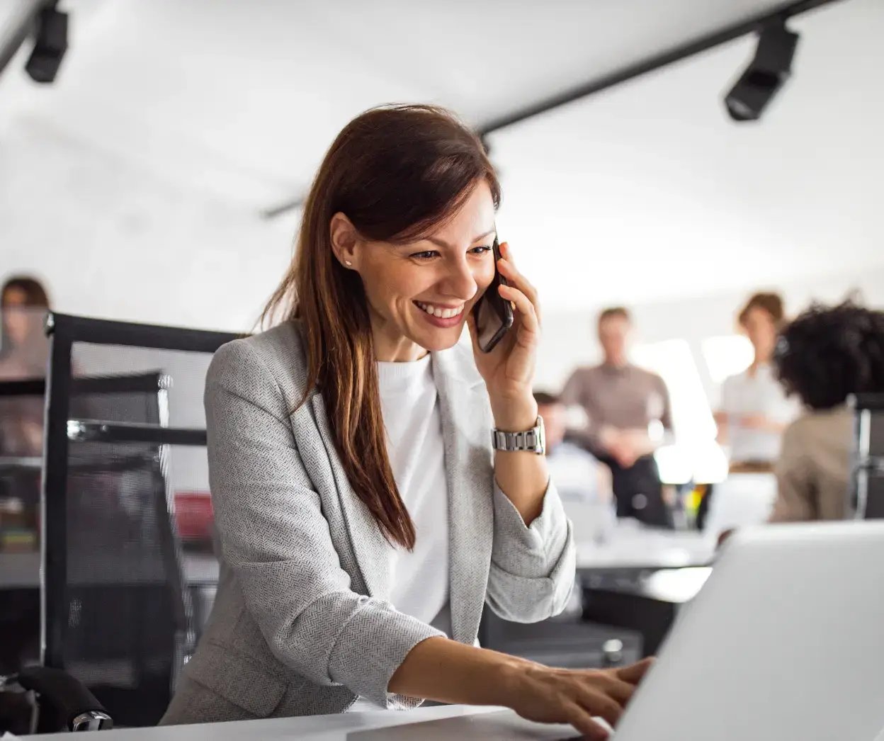 woman on phone in front of laptop